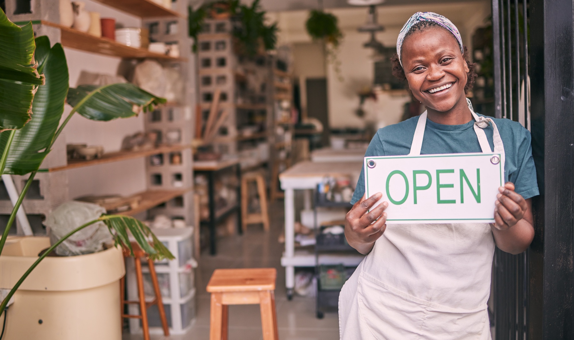 Creative business owner holding open sign